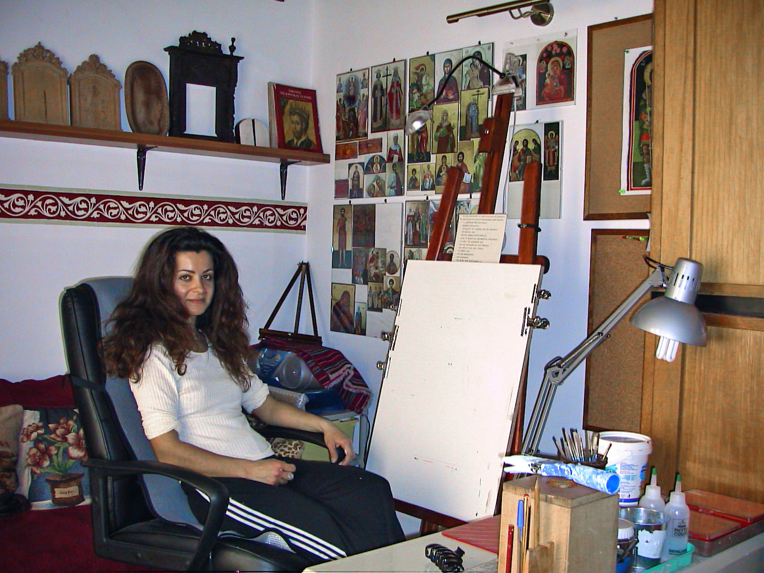 Alexandra Kaouki standing in front of her Byzantine icon paintings.