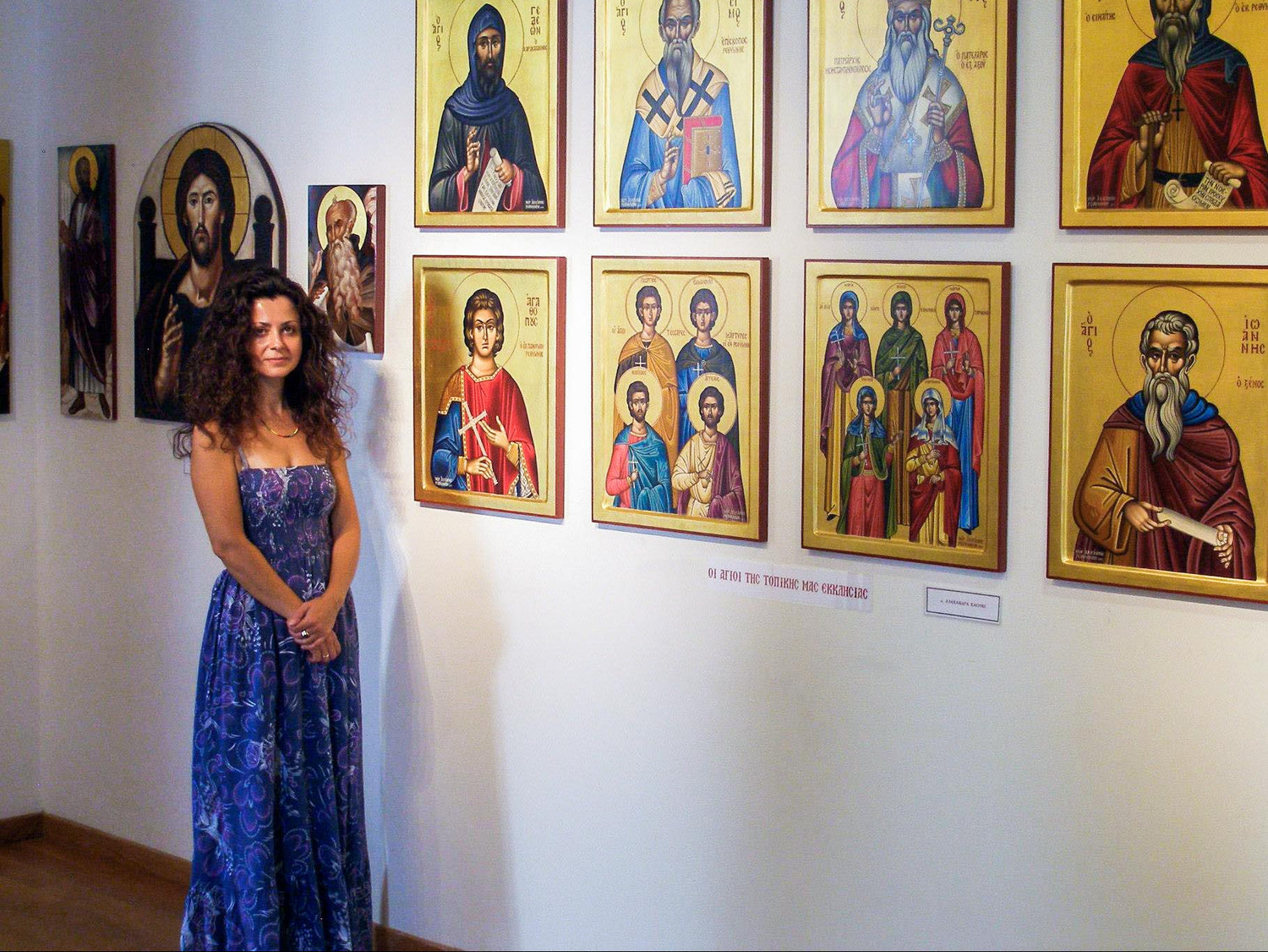 Alexandra Kaouki standing in front of her Byzantine icon paintings during an exhibition