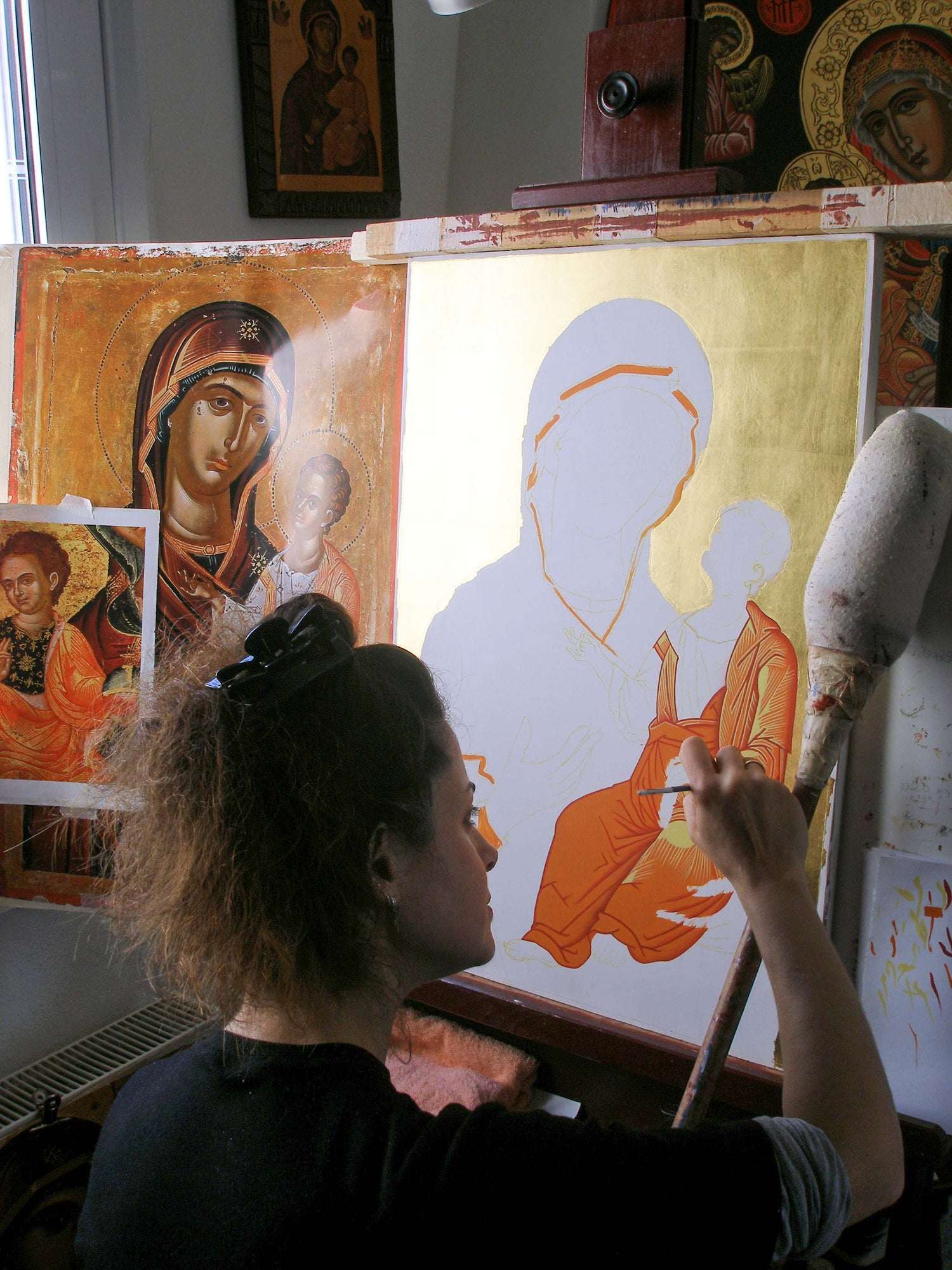 Alexandra Kaouki painting a Byzantine icon of the Virgin Mary with Christ